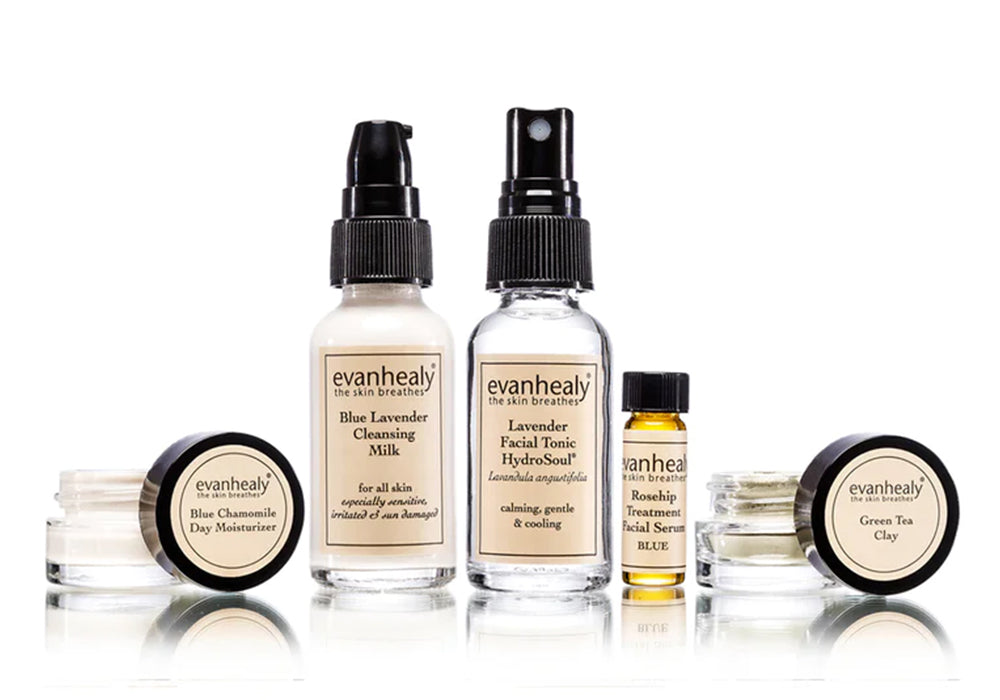 Front view of Calming Starter set: cleanser pump, facial tonic spray, rosehip serum vial, moisturizer and clay jars on white