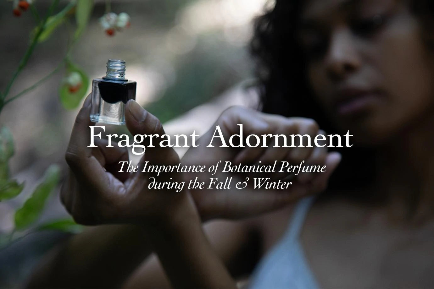 Woman holding a small glass perfume vial near green seed pods, overlaid headline Fragrant Adornment