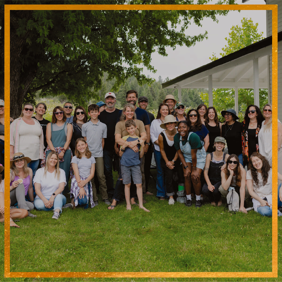 Group of Morning Myst Botanics farmers and community members gathered on grass in front of a white pavilion in the Columbia River Valley