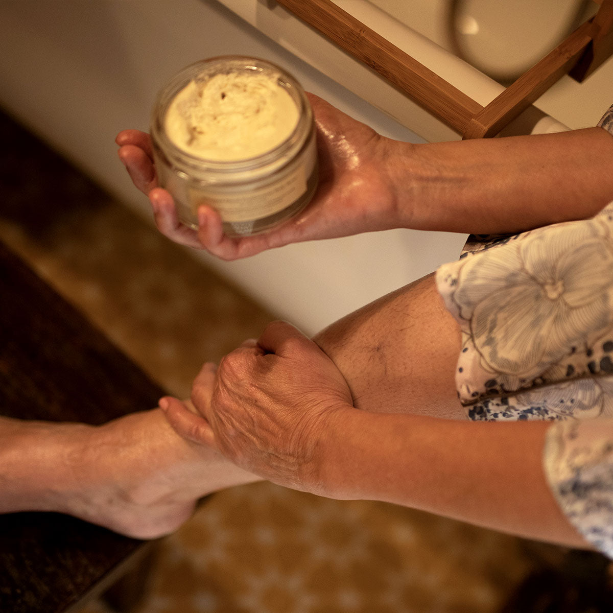 model applying whipped patchouli vanilla body moisturizer to leg