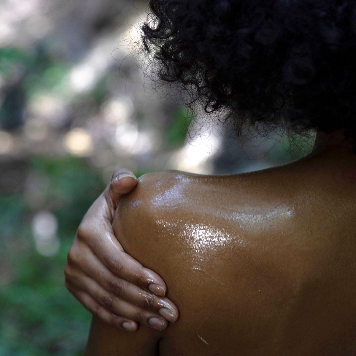 person rubbing evanhealy shea butter moisturizer on shoulder
