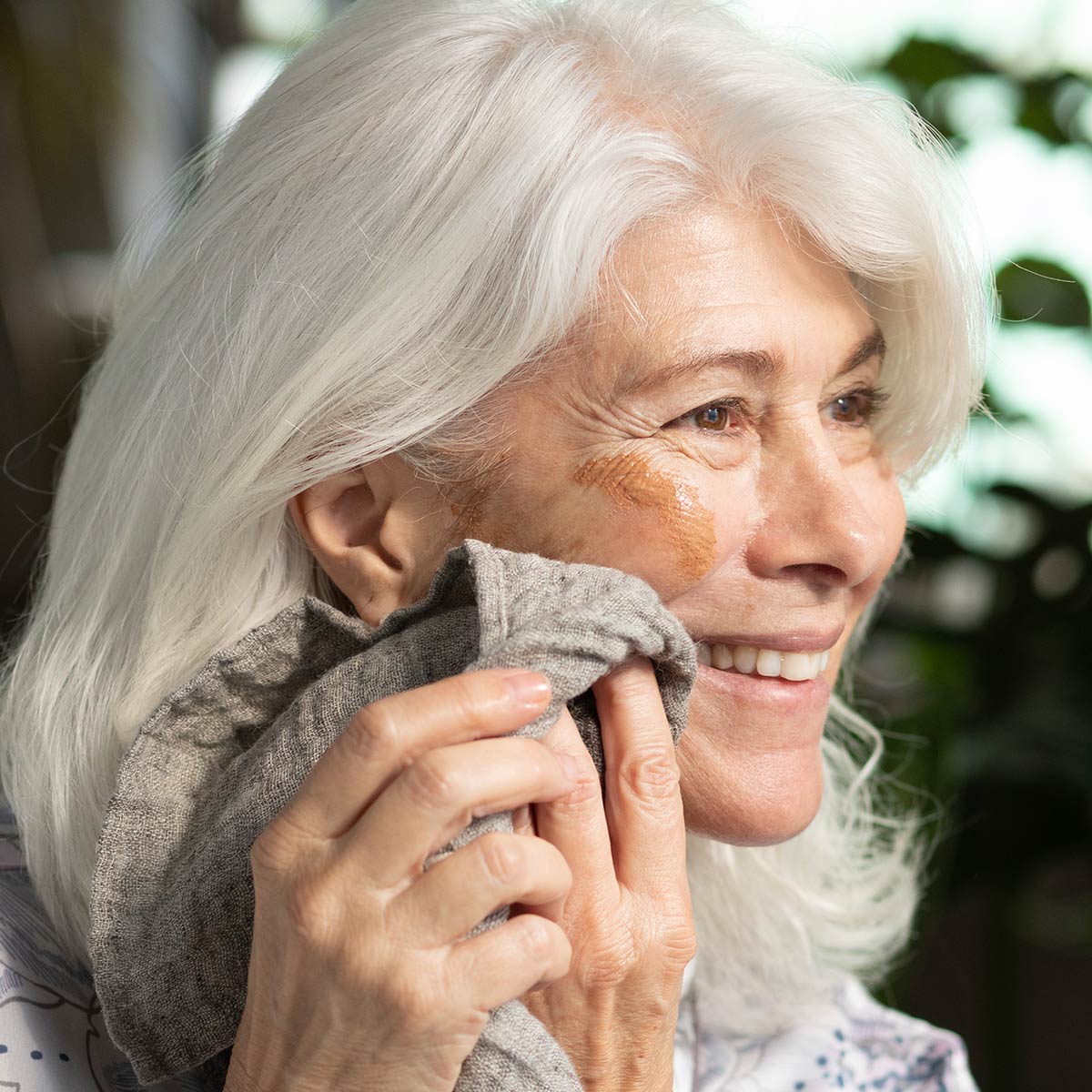 model wiping french rose clay mask off face with natural linen wash cloth
