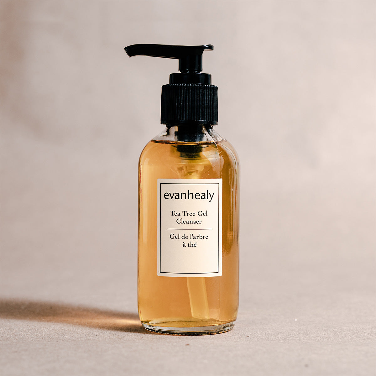 Front view of Tea Tree Gel Cleanser showcasing its amber gel and black pump bottle with a neutral background