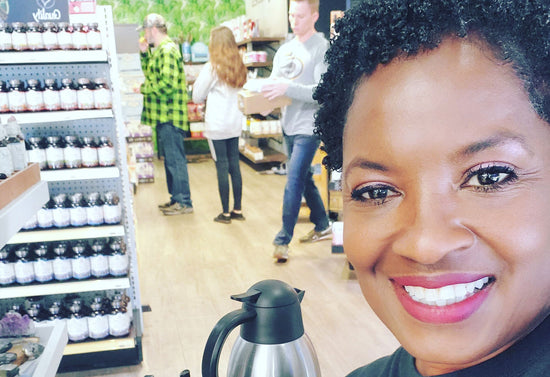 Dorothea Johnson smiles for a selfie in a store with evanhealy products on display