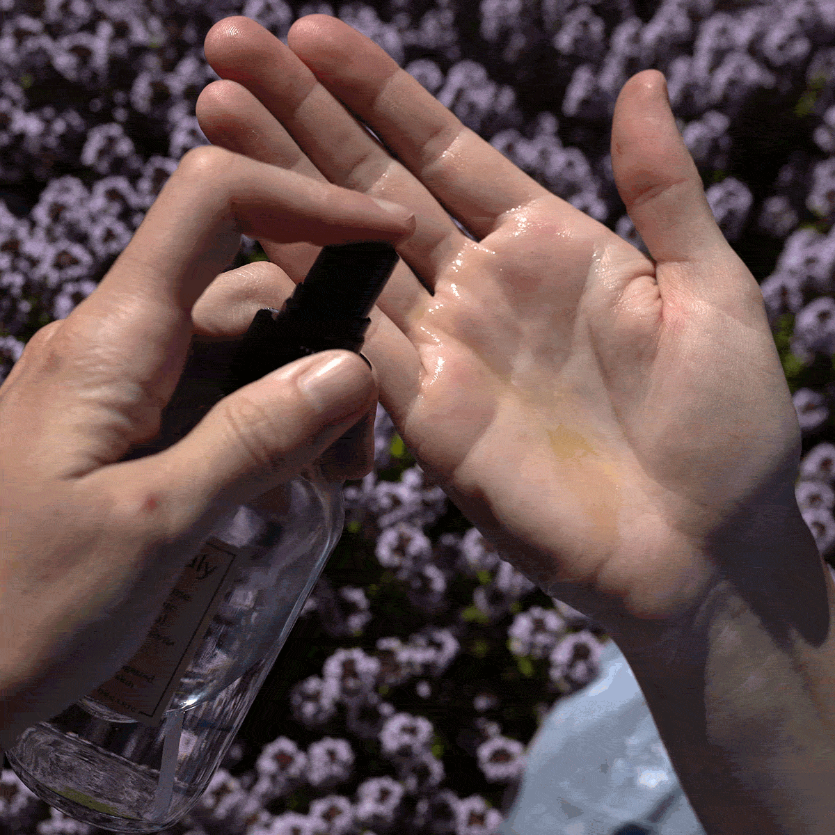 Hands apply purifying oil serum with a bottle visible against a floral background