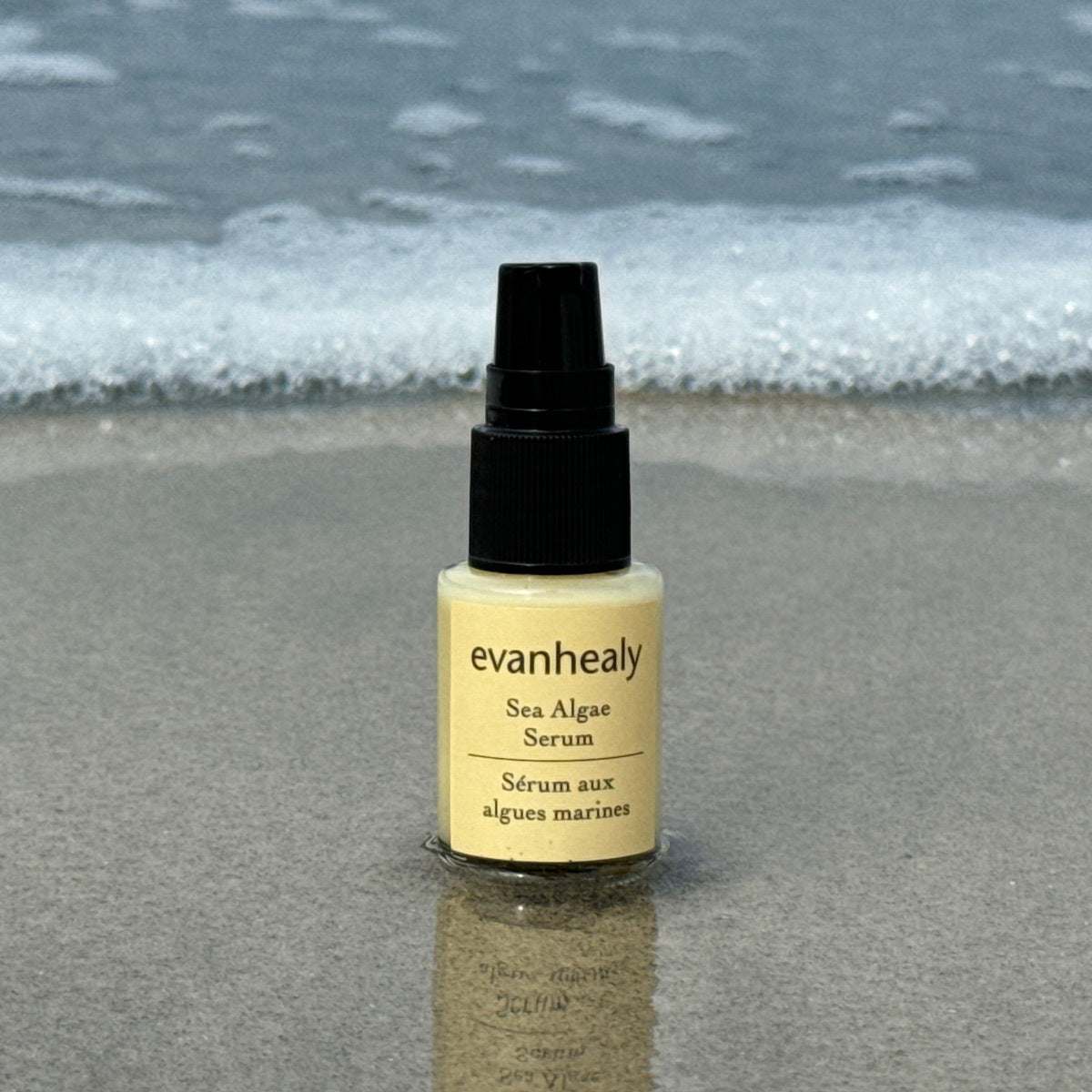 Front view of Sea Algae Serum bottle showcasing its pump dispenser and yellow label with ocean waves in background